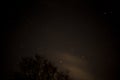 View of stars in a clear night sky with motion in clouds moving acroos the sky above Royalty Free Stock Photo