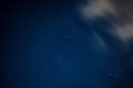 View of stars in a clear night sky with motion in clouds moving acroos the sky above Royalty Free Stock Photo