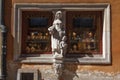 View of a statue of lady with a boy on the facade of a store in a historical building in Warsaw