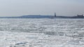 View of the Statue of Liberty and Jersey City across the frozen Hudson River