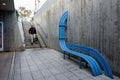 View of a steep public stairwell with wheelchair slope for disability access