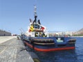 View from the stern of tug boat docked at port dock. Professional boat for port work. Large tugboat berth in the port