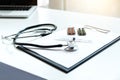 View of stethoscope, drug and equipment on foreground table with