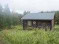 View of STF Njunjes Mountain cabin on a meadow, moody rainy day with thick fog. Wooden cottage lies on the banks of the Royalty Free Stock Photo