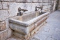 View of a stone fountain with two metal pipes Royalty Free Stock Photo