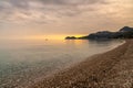 view of the stone pebble beach and clear water at Letojanni on Sicily at sunsest Royalty Free Stock Photo