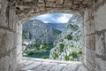 View from stone window of Cetina River, mountains and old town Omis, Croatia. View from above of Cetina river canyon and mouth in Royalty Free Stock Photo