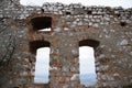 A view of the stony window of the old castle in the background is a village many miles away