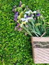 View of a straw ladies bag with flowers on a background of grass.