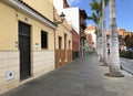 View of street with old colorful houses and palm trees in a row Royalty Free Stock Photo