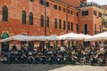 View of a street restaurant or cafe or pizzeria with many people and visitors. Nearby are motorcycles