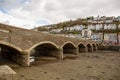 View of strong stone arched bridge joining East and West Looe at low tide. Looe, Cornwall, UK