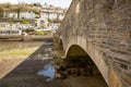 View of strong stone arched bridge joining East and West Looe at low tide. Looe, Cornwall, UK