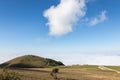 View of Subasio mountain Umbria over valley filled by fog, and beneath a blue sky with white clouds Royalty Free Stock Photo
