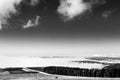 View of Subasio mountain Umbria over valley filled by fog and beneath a wide sky with white clouds Royalty Free Stock Photo