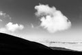 View of Subasio mountain Umbria over valley filled by fog, beneath a wide sky with white clouds