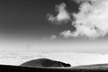 View of Subasio mountain Umbria over valley filled by fog, beneath a wide sky with white clouds Royalty Free Stock Photo