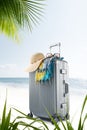 suitcase with hat, pareo and sunglasses on sunny tropic beach