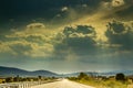 View of sun and rain clouds on rural road