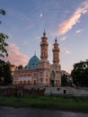 View on Sunni Mukhtarov Mosque in front of summer evening sky with crescent moon and pink clouds on the bank of Terek