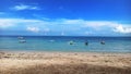 view of a sunny beach with blue skies and white clouds with several traditional fishing boats Royalty Free Stock Photo