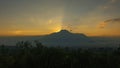 View of a sunrise with the dark silhouette of the Imbabura volcano with the sun rising behind the mountain illuminating the sky Royalty Free Stock Photo