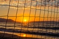 View of the sunrise through the volleyball net. Royalty Free Stock Photo