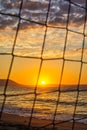 View of the sunrise through the volleyball net. Royalty Free Stock Photo