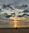 Sea sunset horizon view, silhouette someone sitting alone on the beach in Phangnga Thailand