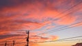 A view of sunset with red and orange clouds and silhouetted electrical power lines Royalty Free Stock Photo