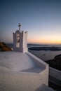 View of the sunset in Santorini with a Christian Greek Orthodox church with a bell tower