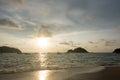 View of a sunset sky and silhouette of floating boats and small island on the beach as foreground