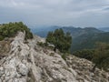 view of Supramonte Mountains with white limestone rock, green trees and valley. Sardinia, Italy. Summer cloudy day