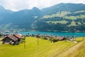 View of swiss village Lungern with traditional houses along the lake Lungerersee, canton of Obwalden, Switzerland. Royalty Free Stock Photo