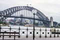 View of Sydney Harbour Bridge from the Circular Quay on a wet morning, with city in the distance and a ferry crossing over Royalty Free Stock Photo