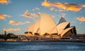 View of Sydney Opera House the water with golden sunset glow in Sydney, Australia Royalty Free Stock Photo