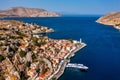 View on Symi (Simi) island harbor port, classical ship yachts, houses on island hills, Aegean Sea bay.