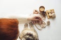 Cat looks up right to camera. Young woman with red hair drink latte