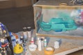 View of table with hand made box for painting of small plastic objects with spray color