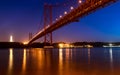 View of the Tagus River and the 25 of April Bridge Ponte 25 de Abril at night, in Lisbon, Portugal. Royalty Free Stock Photo