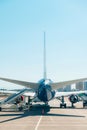 View of the tail section of the aircraft. Passenger plane parked at the airport with a gangway. Royalty Free Stock Photo