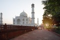 A view of the Taj Mahal, Agra, at sunrise, with a path and trees