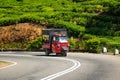 View on tea plantation in Ella Sri Lanka. Small red tuktuk, local transport, ride on the road.