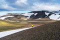 View of teenage girl in yellow winter dress walking in the beautiful snow covered mountain landscape of highlands Royalty Free Stock Photo