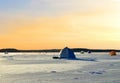 View of tents camping on ice of the river during ice fishing. Fishermen on frozen lake catch fish in hole of ice on the sunset Royalty Free Stock Photo