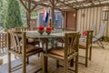 View of a terrace with a wooden table with two red candles, chairs, two reclining chairs and the flag of Holland in the background