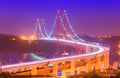 View of The 25th April Bridge Ponte 25 de Abril with car light trails in haze. Popular landmark of Lisbon, Portugal Royalty Free Stock Photo