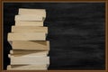 View of thick books lined up in a row and black chalk board in background