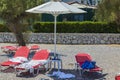 View of things and shoes of tourists left on sun loungers on beach. Greece. . Royalty Free Stock Photo