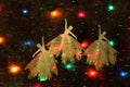 View of three dancing ballerinas made of paper surrounded by colorful lights